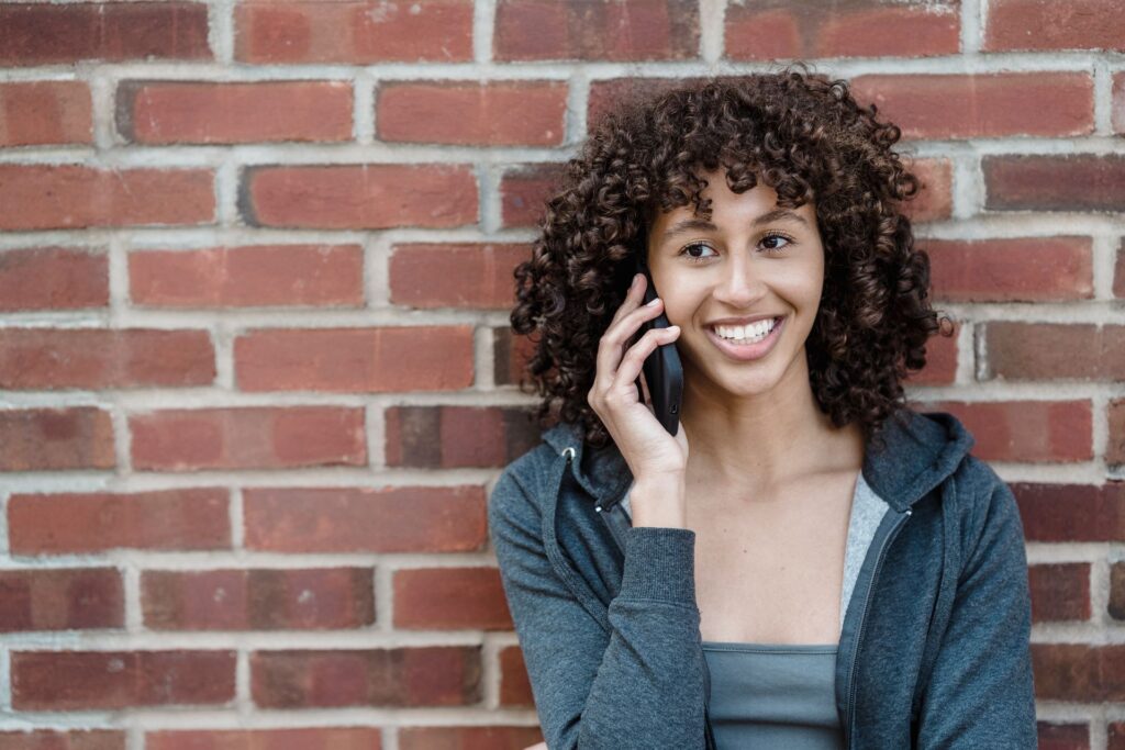 Smiling woman booking on her phone