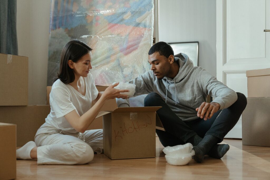 Couple relaxing among boxes in their new home